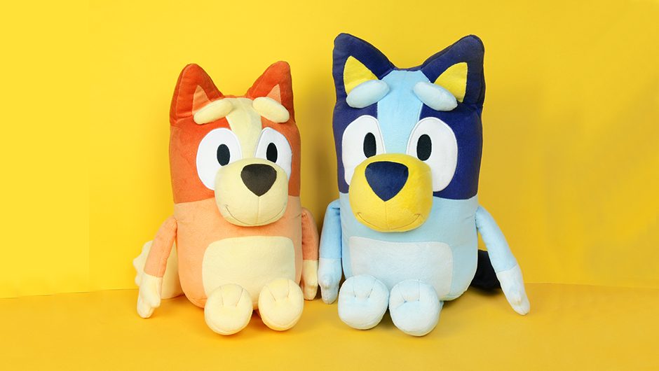 Bingo and Bluey toy plushes sat next to each other against a yellow background.