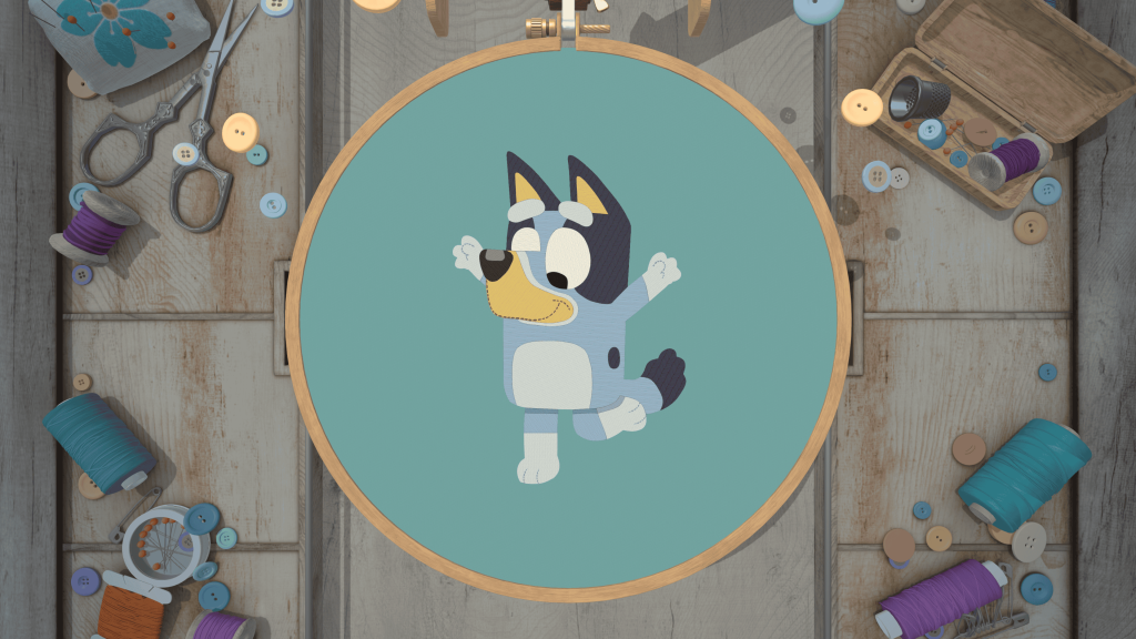 Bluey Stitch inside a wooden embroidery hoop, surrounded by sewing tools, thread and buttons.